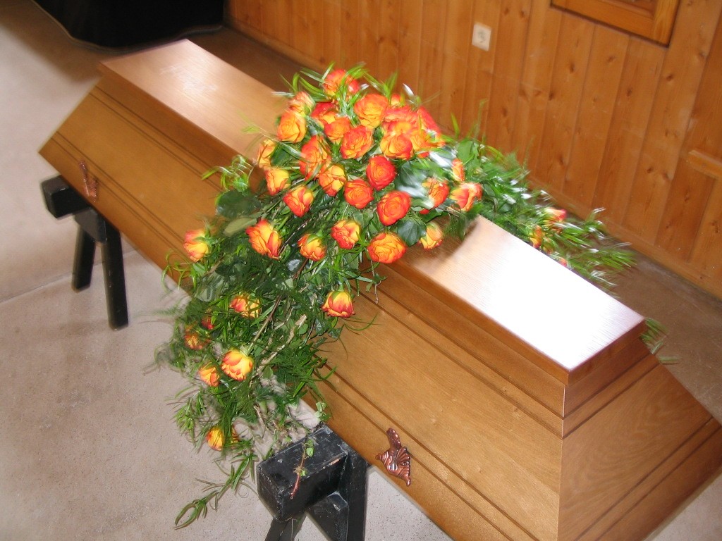 Sargbukett mit orangenen Rosen Bild 1